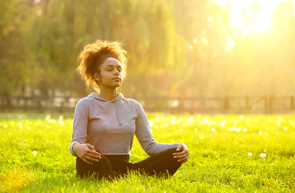 Young african american woman meditating in nature