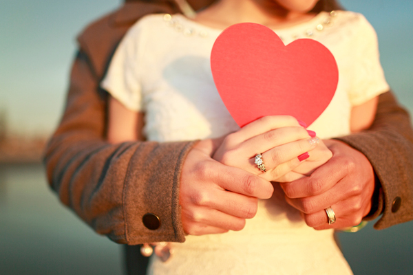 Man and woman holding a red heart shape